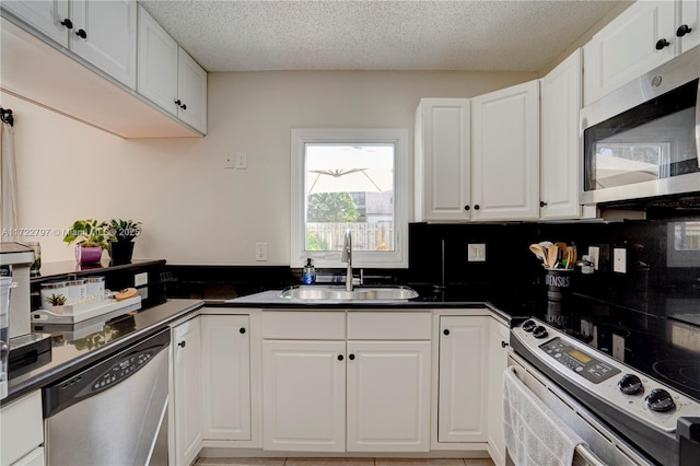 kitchen featuring stainless steel appliances, white cabinetry, and a sink