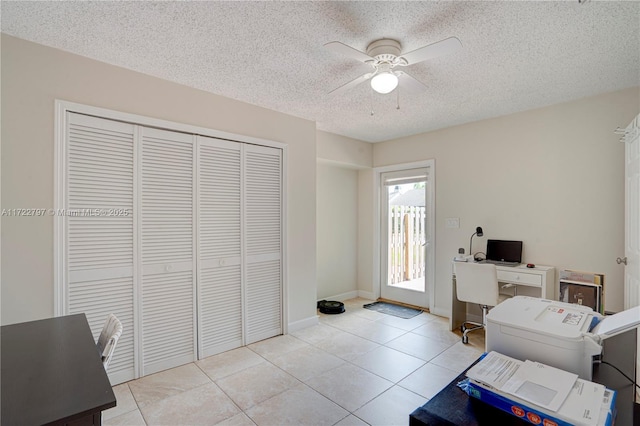 office area with light tile patterned floors, ceiling fan, a textured ceiling, and baseboards