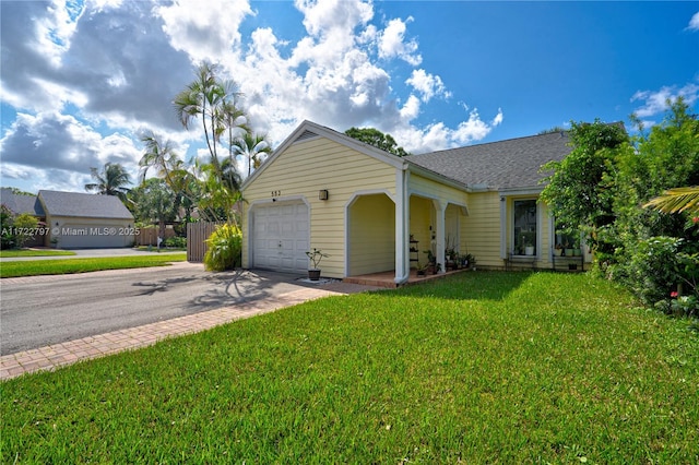 ranch-style home featuring a garage, a shingled roof, a front lawn, and concrete driveway