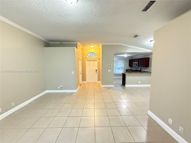 unfurnished room featuring light tile patterned floors, a textured ceiling, vaulted ceiling, and crown molding