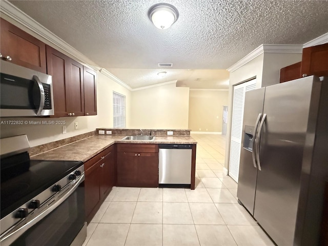 kitchen featuring kitchen peninsula, appliances with stainless steel finishes, ornamental molding, sink, and light tile patterned flooring