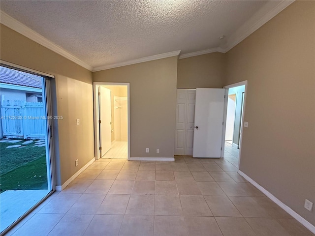 unfurnished bedroom with a textured ceiling, light tile patterned floors, crown molding, and vaulted ceiling