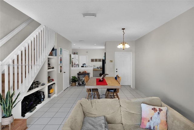 interior space with built in features, a notable chandelier, and light tile patterned flooring