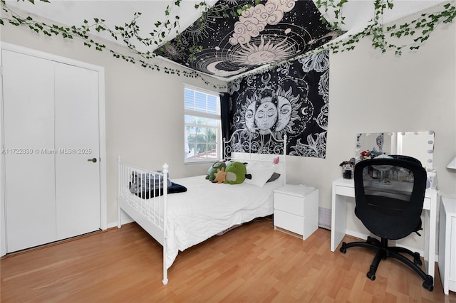 bedroom with wood-type flooring and a closet