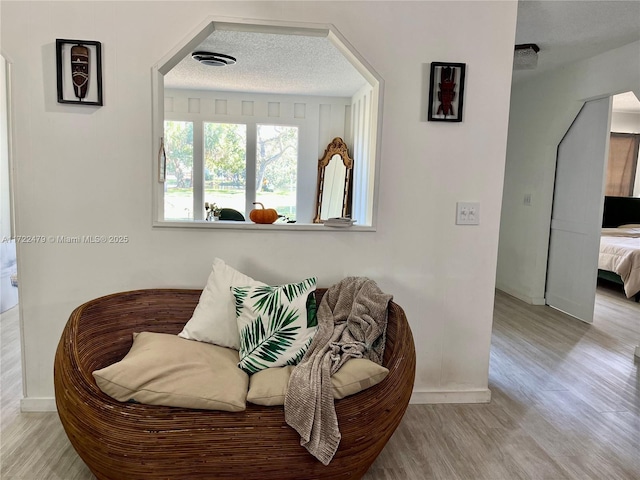 sitting room with a textured ceiling and light hardwood / wood-style flooring