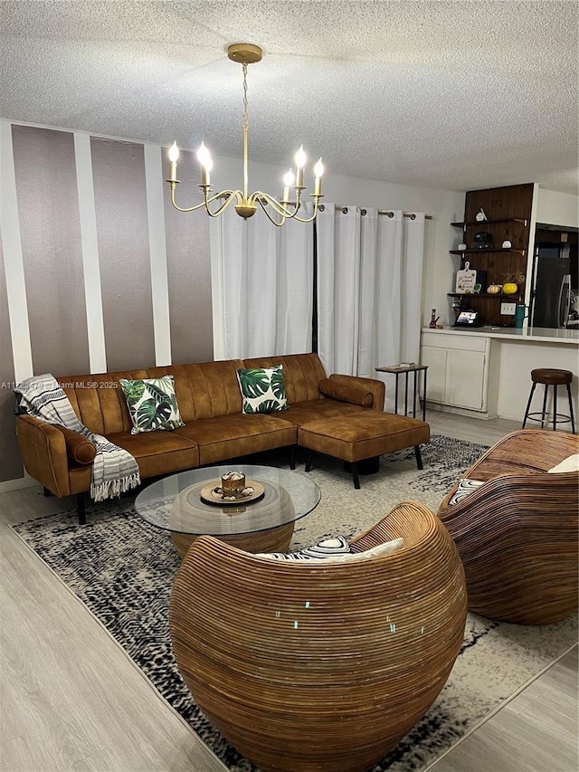 living room featuring a textured ceiling, hardwood / wood-style flooring, and a notable chandelier