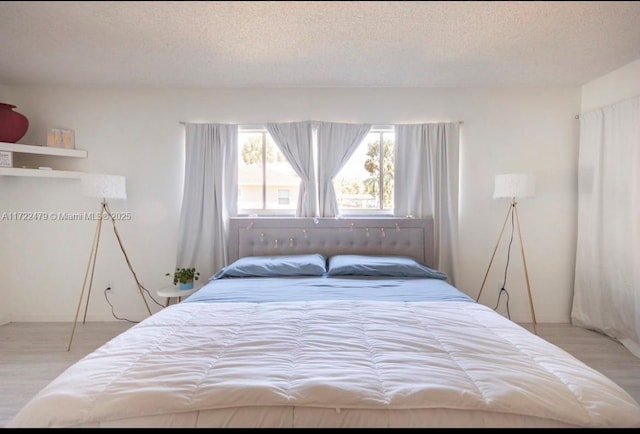 bedroom with light hardwood / wood-style floors and a textured ceiling