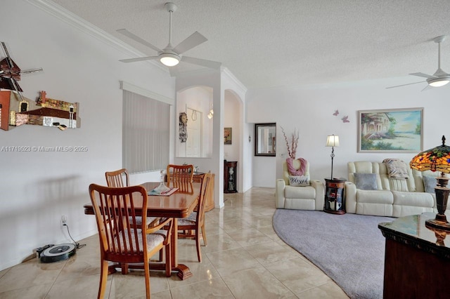 dining space with ceiling fan, light tile patterned flooring, a textured ceiling, and ornamental molding