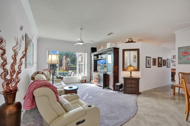 living room with ceiling fan, light tile patterned flooring, ornamental molding, and a textured ceiling