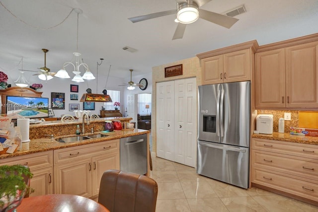 kitchen featuring light brown cabinets, sink, hanging light fixtures, light stone countertops, and stainless steel appliances