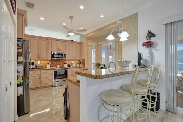 kitchen with stainless steel appliances, light stone counters, kitchen peninsula, decorative light fixtures, and ornamental molding