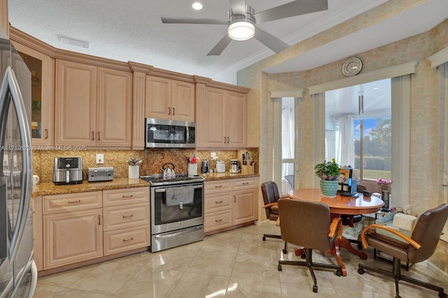 kitchen featuring light stone countertops, light brown cabinets, ceiling fan, stainless steel appliances, and backsplash