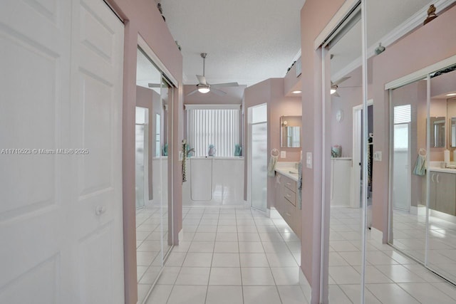 hallway with light tile patterned flooring and a textured ceiling