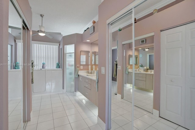 bathroom with tile patterned flooring, vanity, a textured ceiling, and ceiling fan