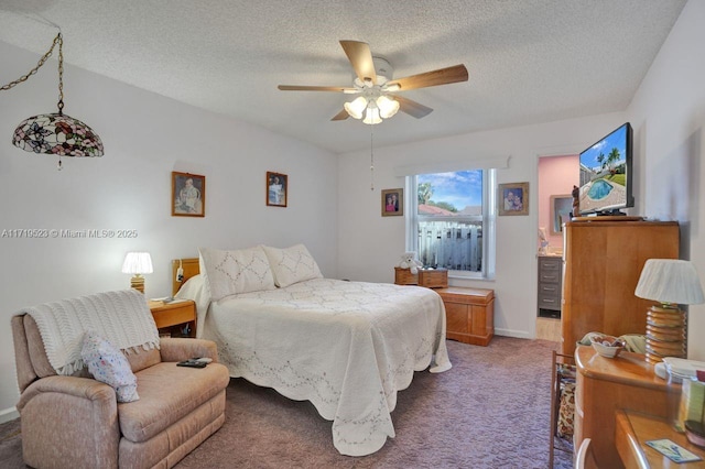 carpeted bedroom with ceiling fan and a textured ceiling