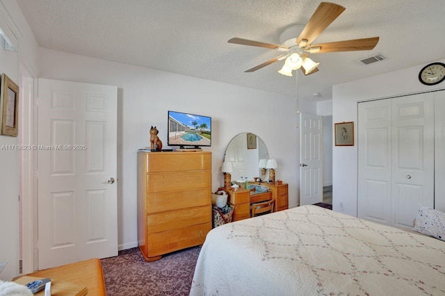 bedroom with dark colored carpet, a textured ceiling, a closet, and ceiling fan