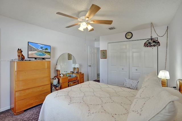 bedroom with dark colored carpet, a textured ceiling, a closet, and ceiling fan