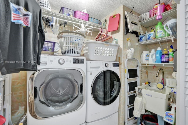 laundry area featuring a textured ceiling and washer and clothes dryer