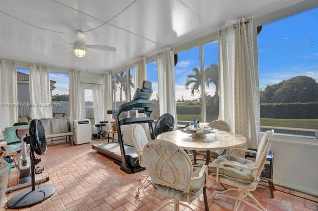 sunroom featuring ceiling fan and a wealth of natural light