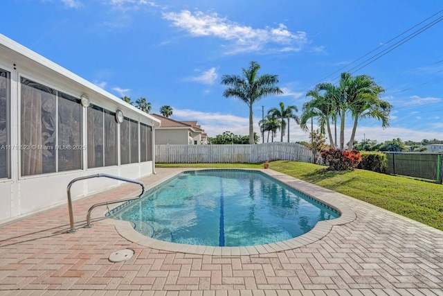 view of swimming pool featuring a yard, a patio, and a sunroom