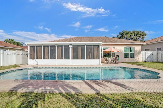 view of pool with a sunroom and a patio