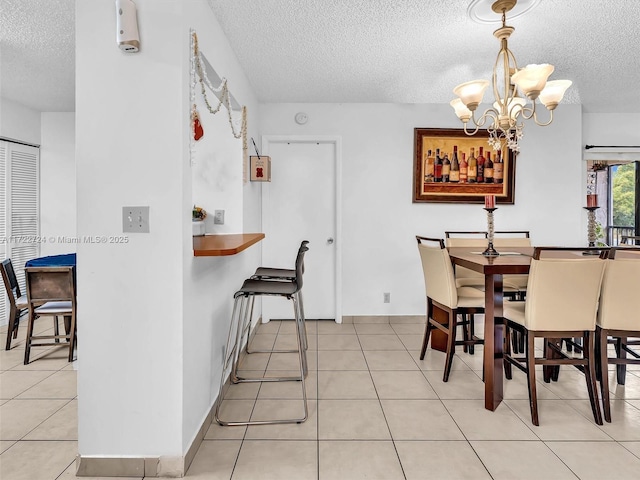 dining room featuring light tile patterned flooring, a textured ceiling, and a chandelier