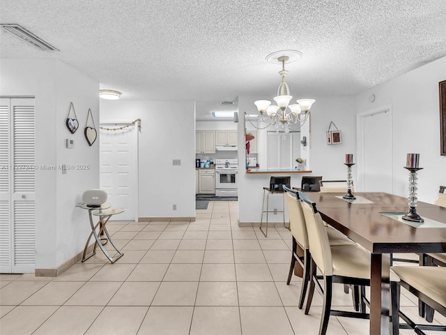 dining room featuring light tile patterned floors, a textured ceiling, and a chandelier