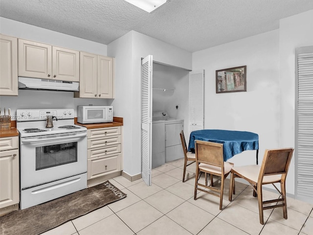 kitchen featuring a textured ceiling, light tile patterned flooring, white appliances, and independent washer and dryer