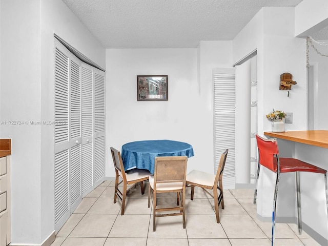 dining room with light tile patterned floors and a textured ceiling