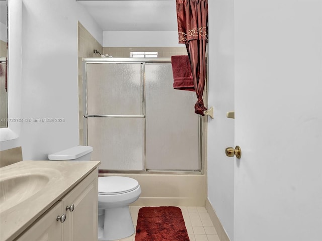 full bathroom with shower / bath combination with glass door, tile patterned floors, vanity, and toilet