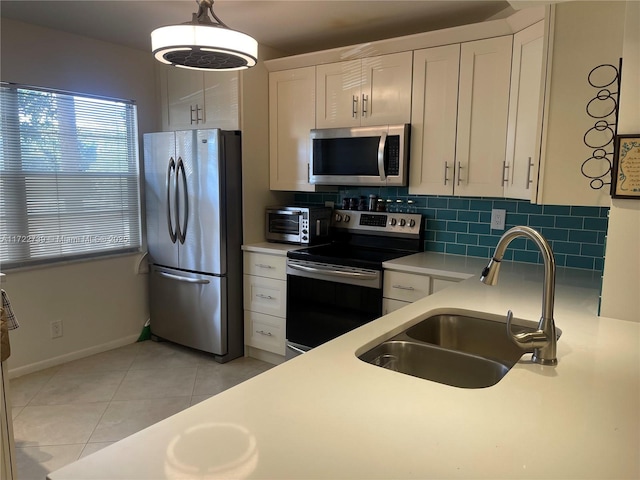 kitchen featuring backsplash, sink, white cabinets, and stainless steel appliances