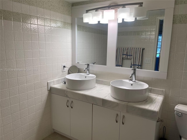 bathroom featuring tile walls, backsplash, vanity, and toilet