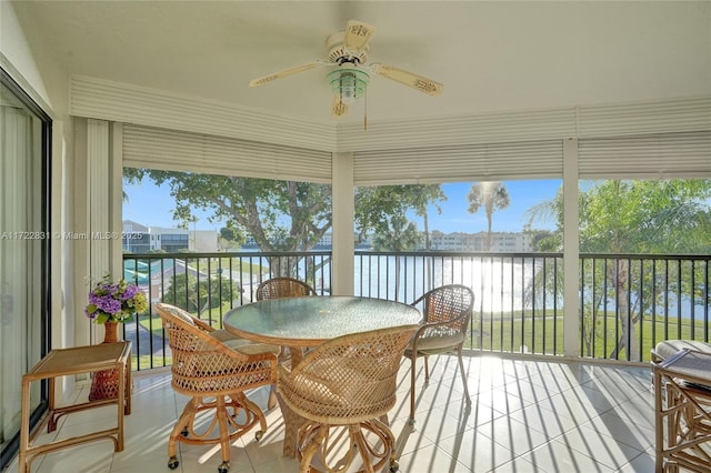 sunroom / solarium with ceiling fan, plenty of natural light, and a water view