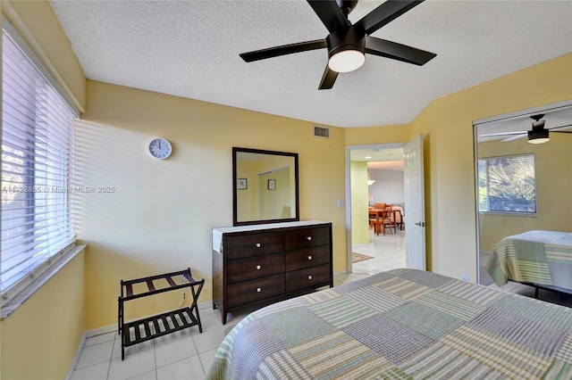 tiled bedroom featuring a textured ceiling and ceiling fan