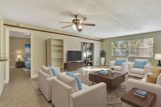 living room with a textured ceiling, ceiling fan, and light tile patterned flooring