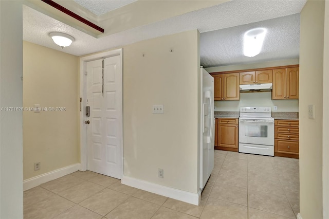 kitchen featuring light tile patterned floors, white appliances, and a textured ceiling