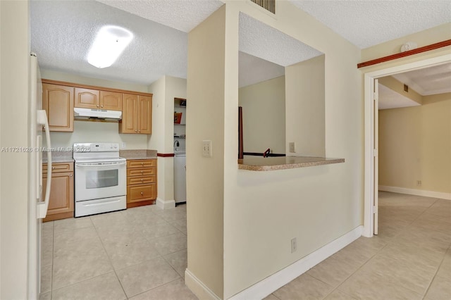 kitchen with light brown cabinets, washer / clothes dryer, a textured ceiling, white appliances, and light tile patterned floors