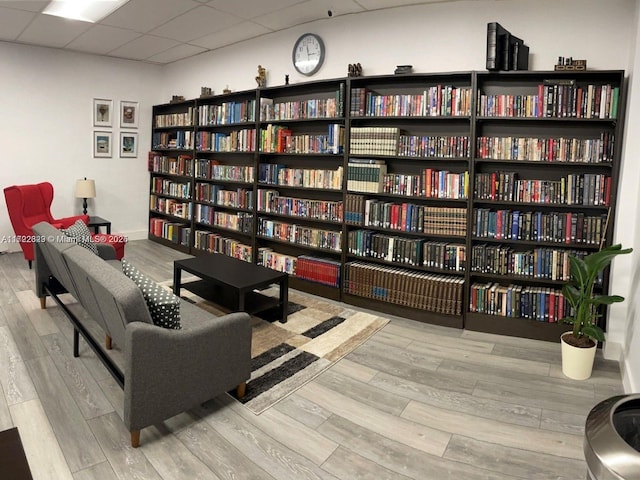 living area with light hardwood / wood-style flooring and a drop ceiling