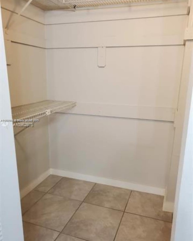 spacious closet with light tile patterned floors