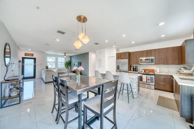 dining area with ceiling fan and sink