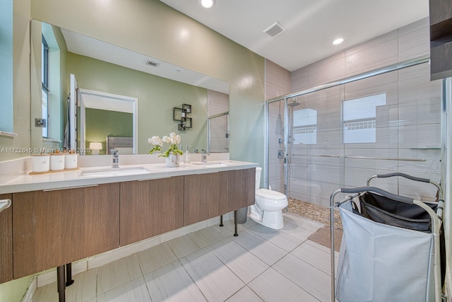 bathroom with tile patterned flooring, vanity, toilet, and a shower with shower door