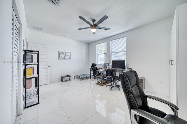 office space featuring ceiling fan and a textured ceiling