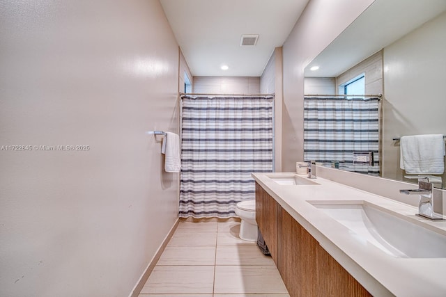 bathroom with tile patterned flooring, vanity, toilet, and walk in shower