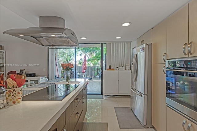 kitchen with a wall of windows, island exhaust hood, cream cabinets, light tile patterned floors, and appliances with stainless steel finishes