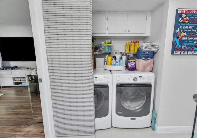 washroom with cabinets, tile patterned flooring, and washer and clothes dryer