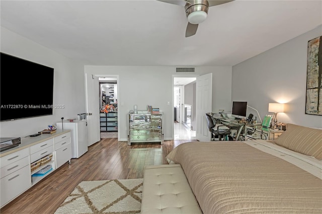 bedroom with ceiling fan, dark hardwood / wood-style flooring, a spacious closet, and a closet