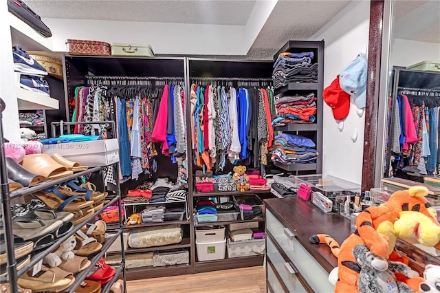 walk in closet with light hardwood / wood-style floors