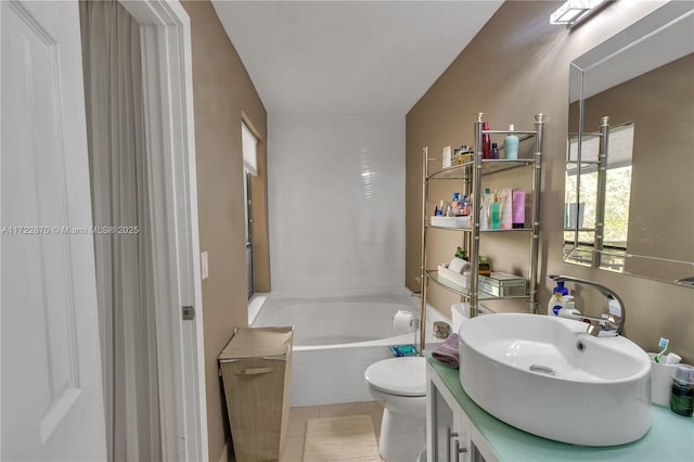 bathroom with tile patterned flooring, vanity, toilet, and a bathtub