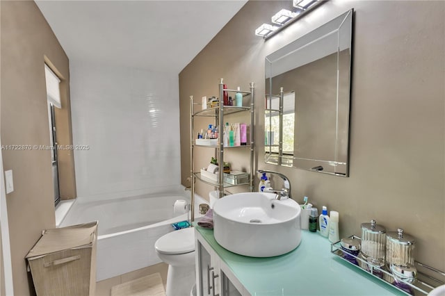 bathroom featuring tiled bath, vanity, and toilet