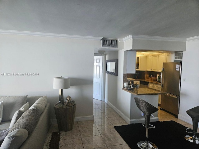 kitchen featuring kitchen peninsula, stainless steel fridge, backsplash, crown molding, and white cabinetry